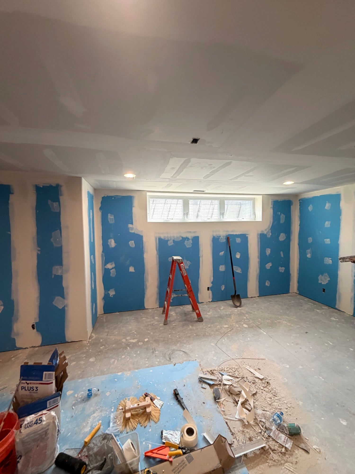 Basement window wall with new drywall hung, taped and mudded