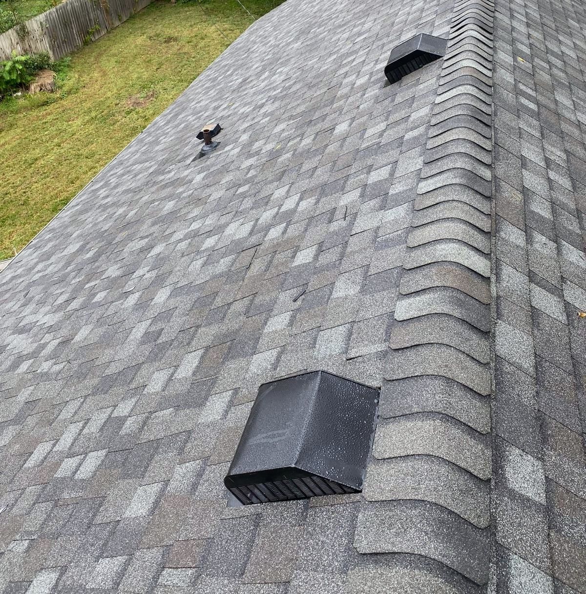 The same roof with new gray architectural shingles and a ridge vent